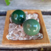 Green Aventurine helps to manifest abundance and luck in all areas of life - financial, love, work, etc... It removes negative energy so that you can overcome any obstacles blocking you from reaching your full potential. Promotes vitality & it’s strong connection to Earth which also makes it a perfect companion to any plant in need of growth. Green Aventurine is connected to the Heart Chakra. The sphere is said to be the universal body and the point of creation, it’s the only crystal shape that sends energy evenly in all directions Hold one in each hand during meditation, while doing mudras, or place one on your Heart to balance that Chakra. This includes TWO Green Aventurine Spheres selected from what’s shown in the pictures, approximately 0.90-0.95". It includes a bamboo tray on a bed of Clear Quartz crystals to amplify the energies. You’ll also receive a drawstring pouch & gift box. Color variances, nicks, imperfections and cracks are the nature of genuine gemstones & crystals.