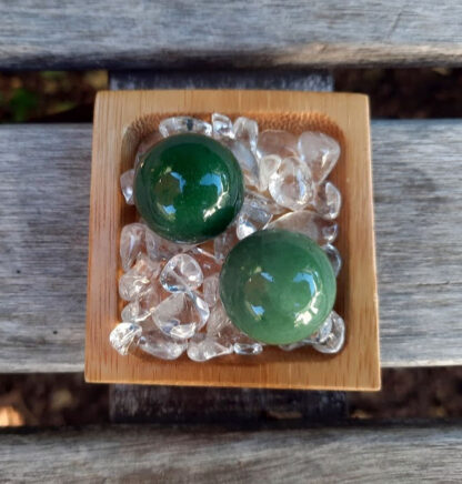 Green Aventurine helps to manifest abundance and luck in all areas of life - financial, love, work, etc... It removes negative energy so that you can overcome any obstacles blocking you from reaching your full potential. Promotes vitality & it’s strong connection to Earth which also makes it a perfect companion to any plant in need of growth. Green Aventurine is connected to the Heart Chakra. The sphere is said to be the universal body and the point of creation, it’s the only crystal shape that sends energy evenly in all directions Hold one in each hand during meditation, while doing mudras, or place one on your Heart to balance that Chakra. This includes TWO Green Aventurine Spheres selected from what’s shown in the pictures, approximately 0.90-0.95". It includes a bamboo tray on a bed of Clear Quartz crystals to amplify the energies. You’ll also receive a drawstring pouch & gift box. Color variances, nicks, imperfections and cracks are the nature of genuine gemstones & crystals.